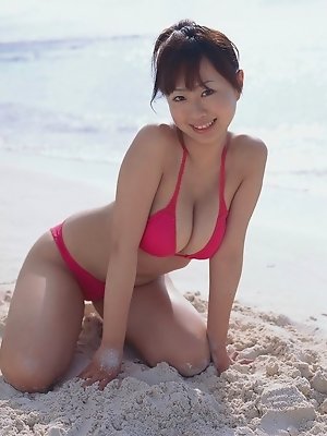 Cute asian babe showing off her tits at the beach in a bikini